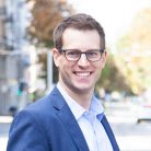Portraitfoto von Stefan Wanner. Steht auf Strasse und unscharf sieht man Bäume, Häuser und Autos im Hintergrund.