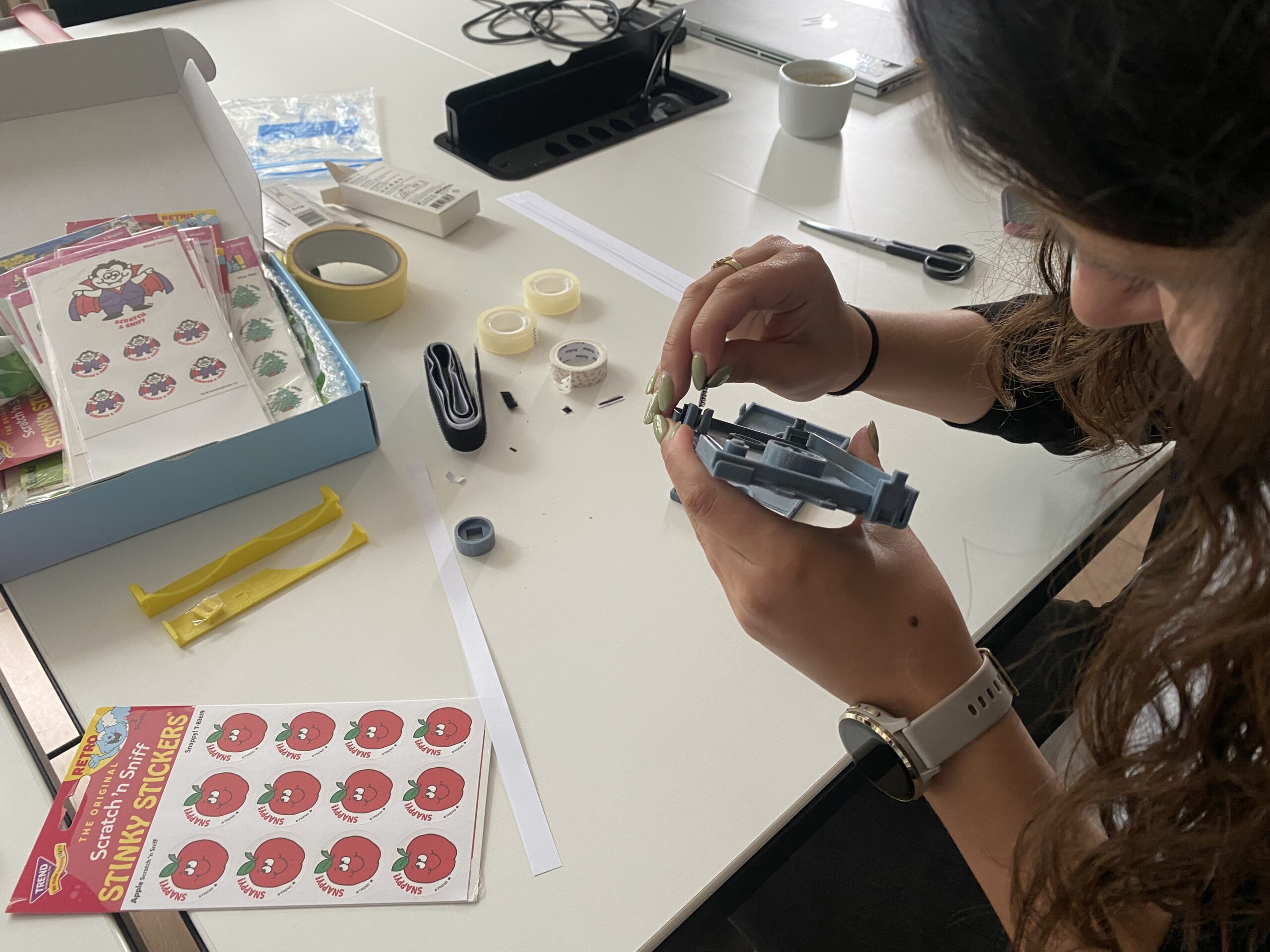 Person klebt Klettband in den Kamm der 3D-gedruckten Kassette